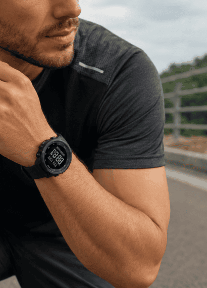 Homem em traje de corrida com relógio esportivo Seculus de pulseira de silicone preta no pulso, em ambiente externo com luz natural, pronto para o treino