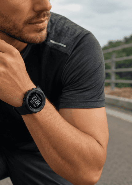 Homem em traje de corrida com relógio esportivo Seculus de pulseira de silicone preta no pulso, em ambiente externo com luz natural, pronto para o treino