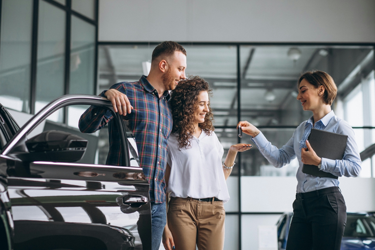Guia de como comprar um carro semi novo - Casal comprando um carro novo da concessionária