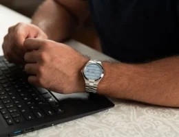 Homem utilizando relógio masculino Seculus Automático Fundo Transparente Visor Azul enquanto trabalha em um notebook, destacando o design elegante e versátil para o cotidiano.